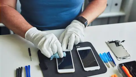 Technik odnawia stary telefon w salonie